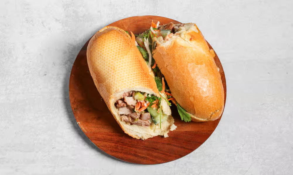 Grilled pork bánh mì on a wooden board